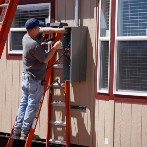 professional standing on red ladder performing electrical work